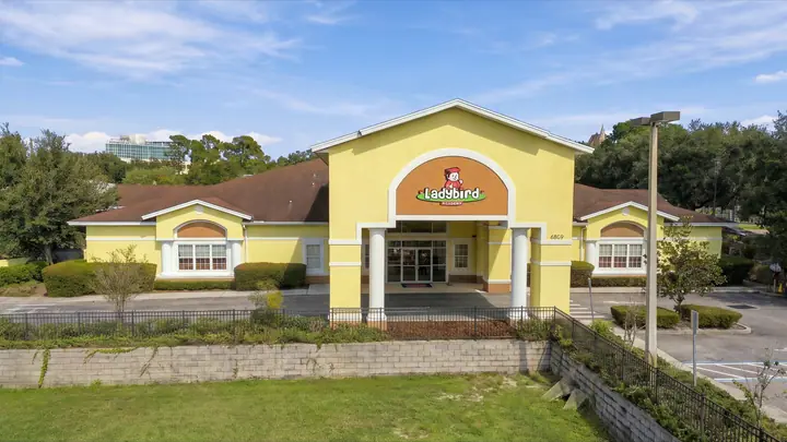 Front entrance of Ladybird Academy of Dr. Phillips, a yellow building with the Ladybird sign