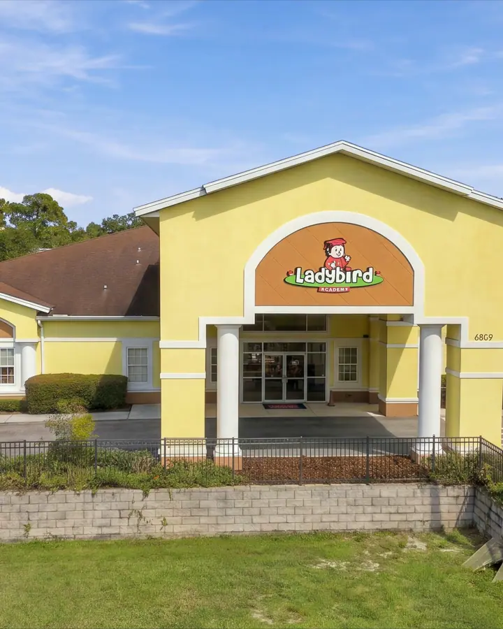 Front entrance of Ladybird Academy of Dr. Phillips, a yellow building with the Ladybird sign