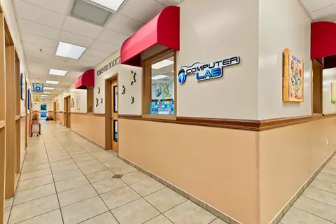 Bright hallway lined with classroom windows and the Computer Lab entrance