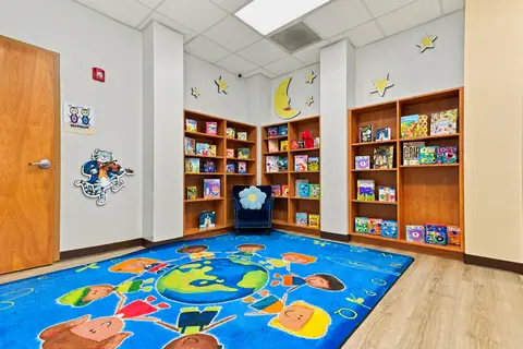 Corner Bookstore reading room with bookshelves and a world-map rug