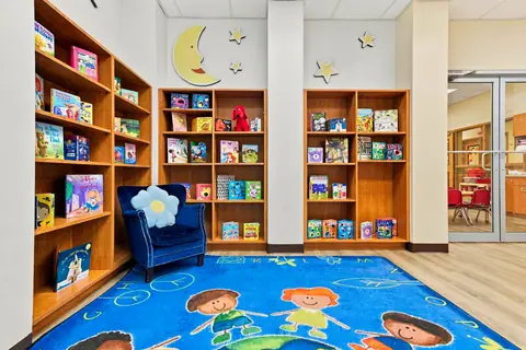 Reading room bookshelves, a cozy armchair and a colorful children's rug