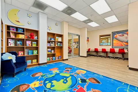 Reading room with bookshelves and a rug opening into the computer lab