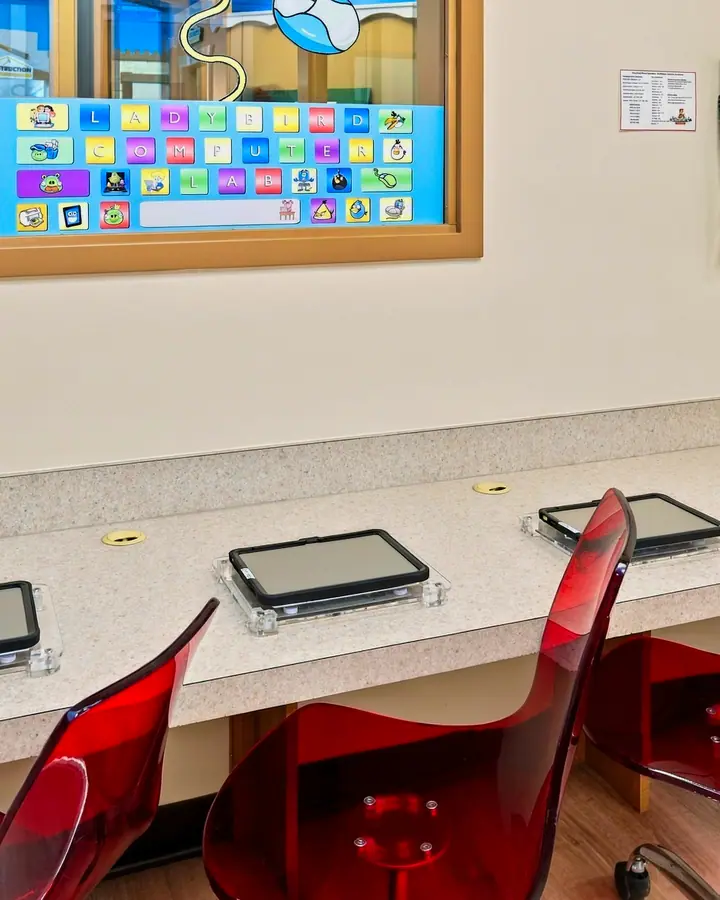 Row of tablets and red chairs in the computer lab