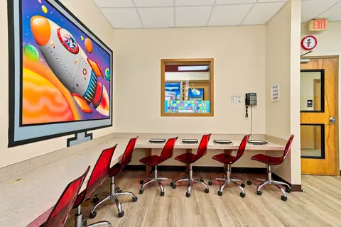 Computer lab with a rocket ship mural and child-height tablet stations