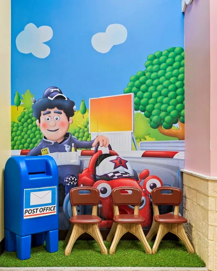 Pretend post office with a mailbox, toy car and child-size chairs