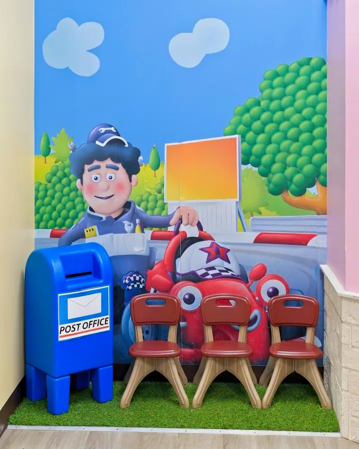 Pretend post office corner with a blue mailbox and toy cars