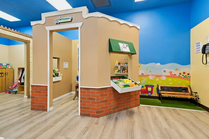 PlayTown market stand beside a park mural