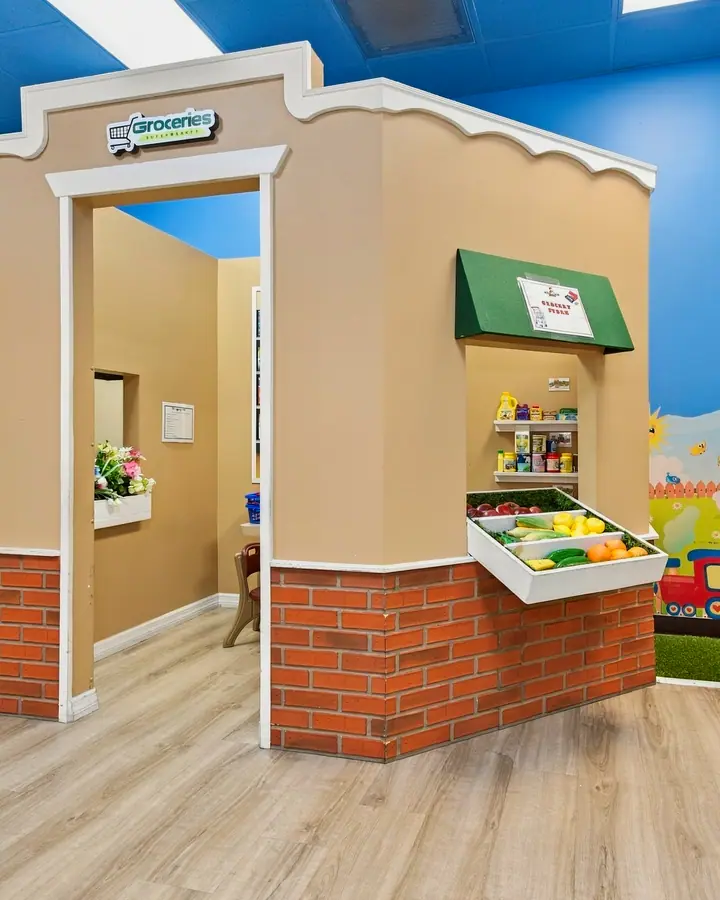 PlayTown market stand beside a park mural