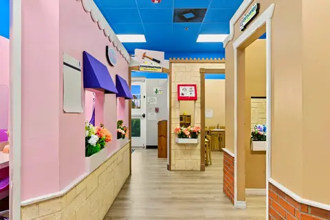 PlayTown main street with pink storefronts and shop doorways