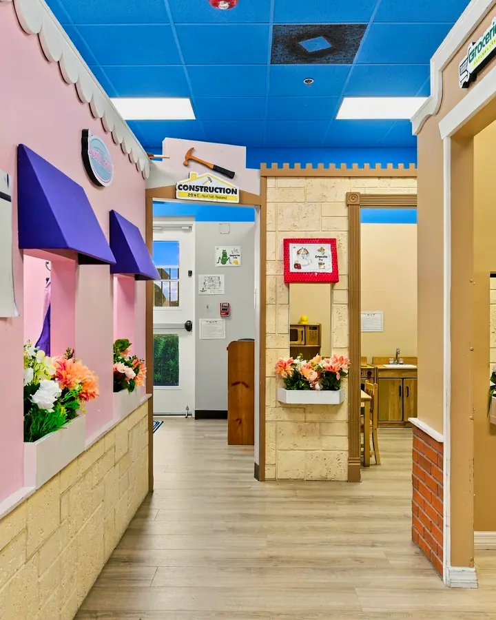 PlayTown main street with pink storefronts and shop doorways