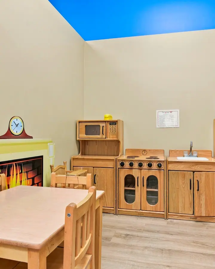 Play kitchen, table and pretend fireplace in the home corner