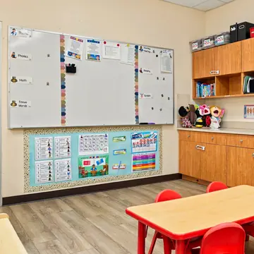 Classroom whiteboard, calendar wall and a red table