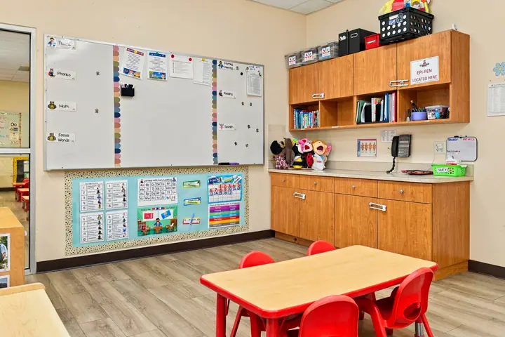 Classroom whiteboard, calendar wall and a red table