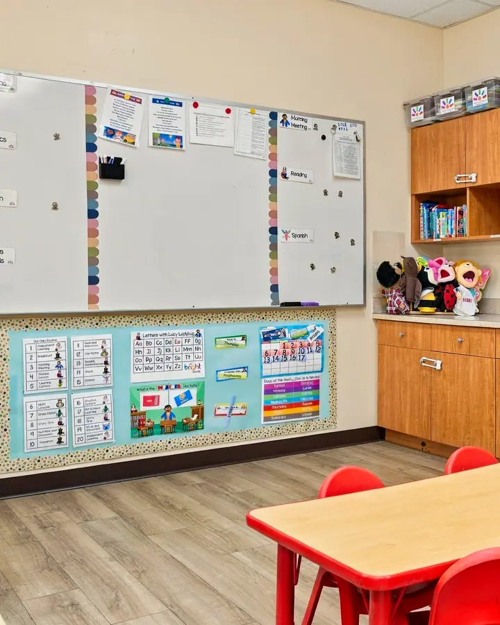 Classroom whiteboard, calendar wall and a red table
