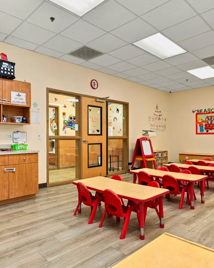 Classroom cabinets, a teaching wall and rows of red tables