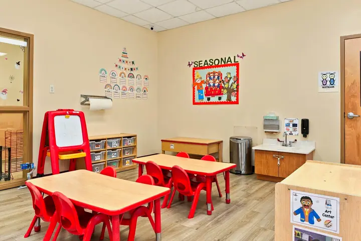Art easel and small tables in a preschool classroom
