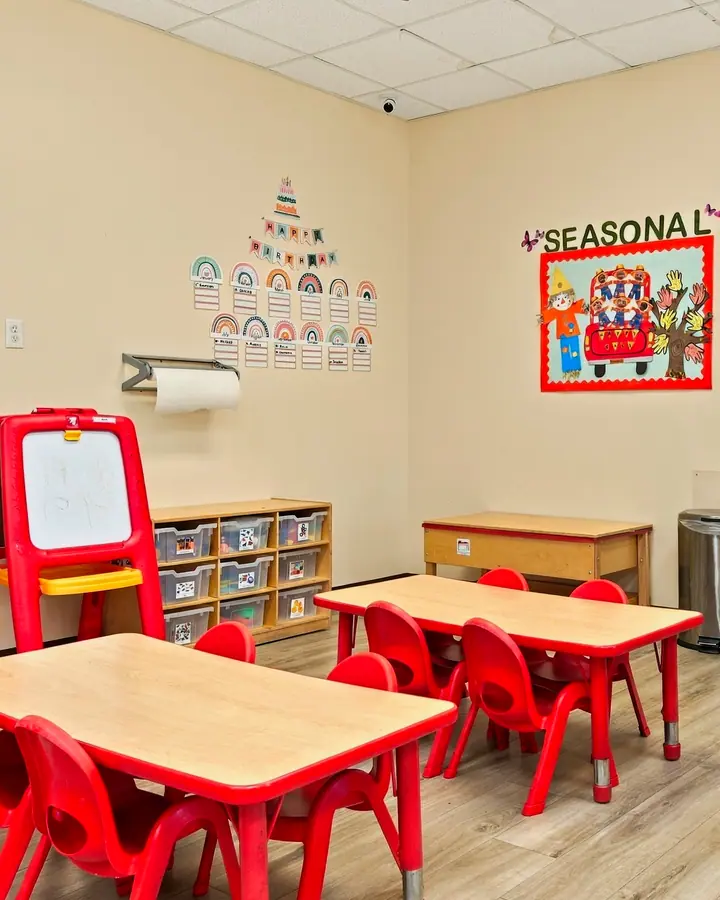 Art easel and small tables in a preschool classroom