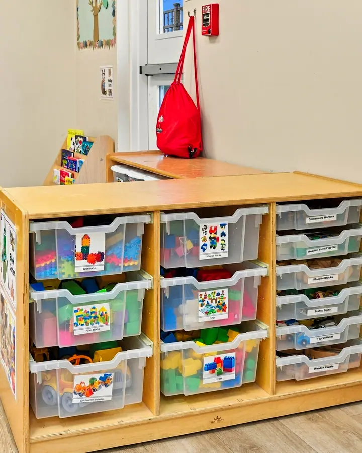 Cozy corner with a small couch beside shelves of learning bins