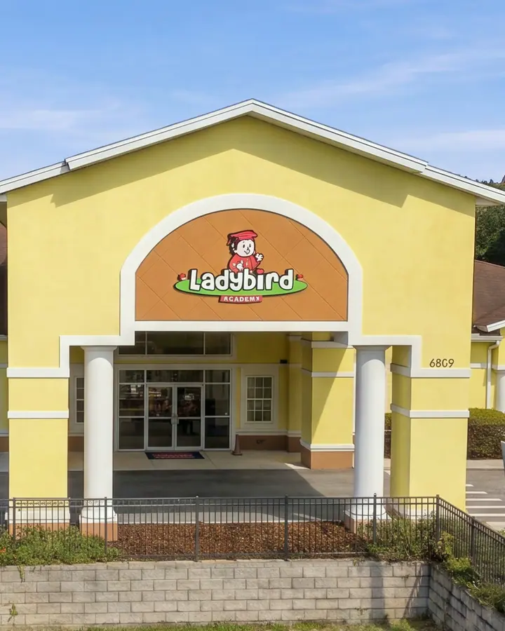 Front entrance of Ladybird Academy of Dr. Phillips, a yellow building with the Ladybird sign